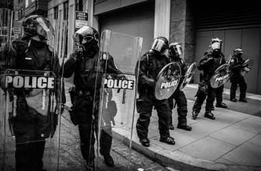 policemen holding clear fiber glass shield